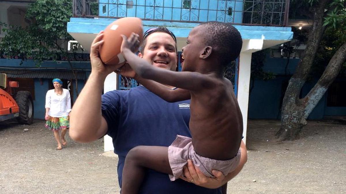 
A clinic in rural Haiti attracts a medical team from Kansas City, which periodically visits to provide eye care in a country sorely lacking in ophthalmologists and other eye experts. Here Scott Hocker teaches a little boy who lives at Northwest Haiti Christian Mission how to throw a football. After the clinic was closed for the day, medical team members played in the courtyard with the children.
