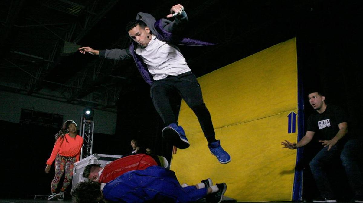 John James flew over fellow performer Erick Nathan and sixth-graders Trey Newton and Dillan Emch while illustrating that an object in motion stays in motion, as fellow FMA performer Sharmaine Tate and crew member Reuben Infante watch.