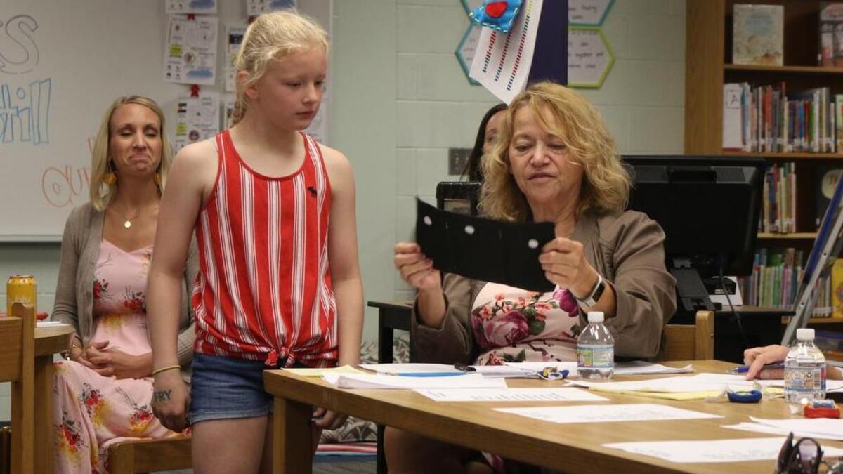 Grace Yeager, 10, shows one of her group's prototype pockets to Pam Lueth of the Federal Reserve Bank.