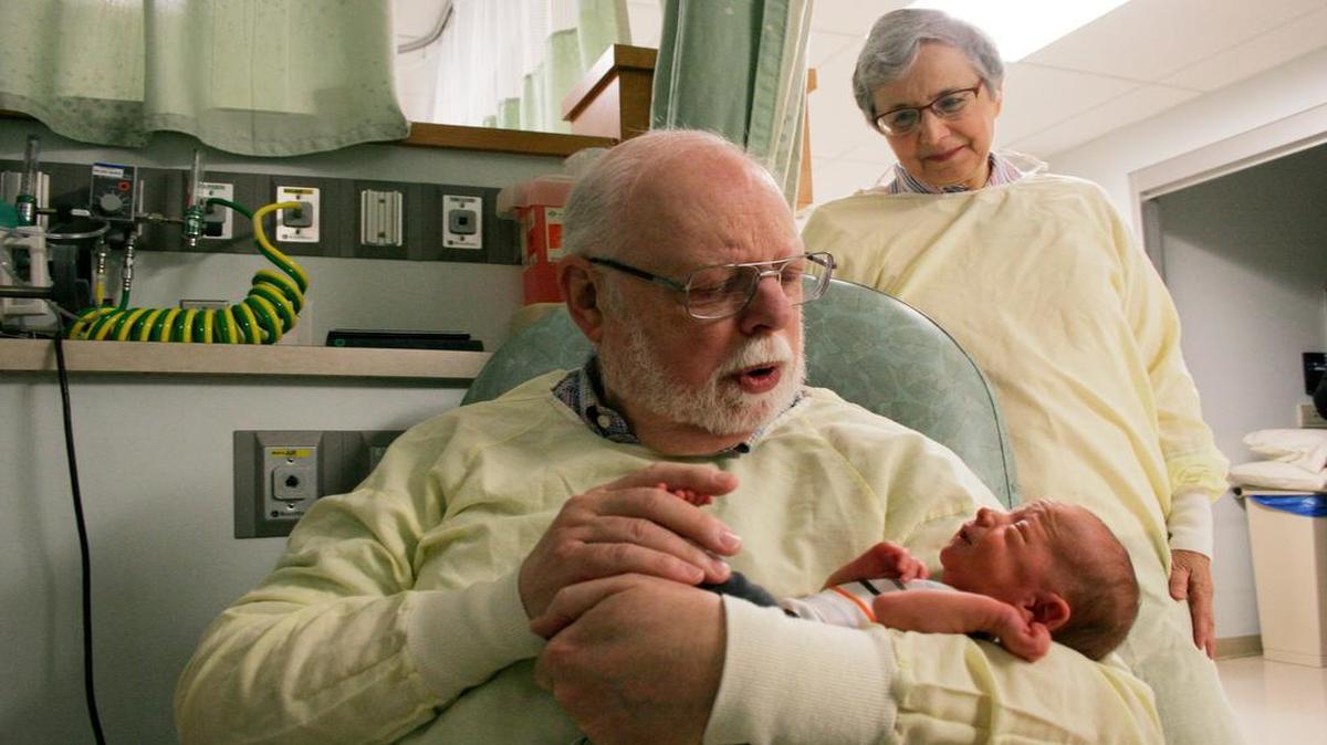 Marshall Weingarten recently held 8-day-old Michael Swope of Raymore as Judy Weingarten watched.