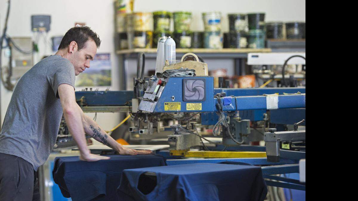 
Screen printer Matt Peters worked Monday on an order of custom-printed T-shirts.

