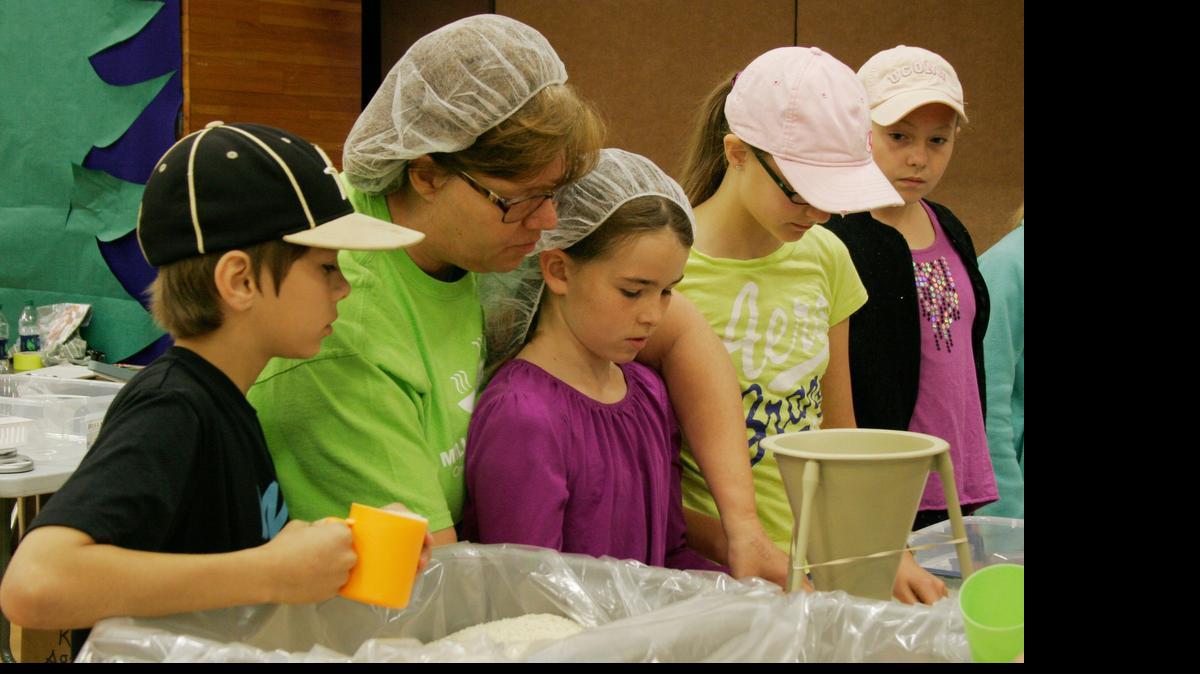 
Drake Mitchem, 10, Kelly Jo Yaksich, co-director of Omaha Kids Against Hunger, Lucie Hoffart, 10, Kelli Marshall, 11, and Emily Bougher, 10, assemble bags of soup mix.
