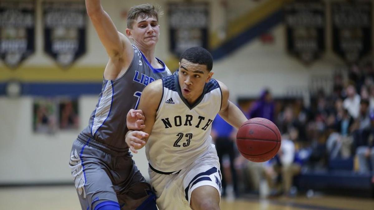 Blue Valley North’s Drew Hubbel (right) drove around a Liberty defender Jan. 6 during the 810 Varsity Showcase at St. Thomas Aquinas. The Mustangs only managed one basket in the fourth quarter and lost 58-49.