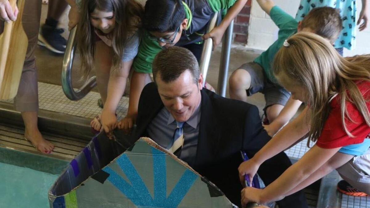 Rosehill Elementary students help steady Sumner as he prepares to sail across the pool at Shawnee Mission South.