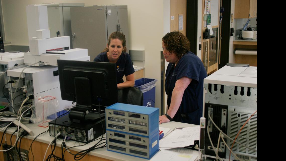 
Melissa Bailey (right) and forensic scientist Julinne Kemp examine a control sample analyzed by a gas chromatograph/mass spectrometer at the Criminalistics Laboratory of the Johnson County Sheriff's Office.
