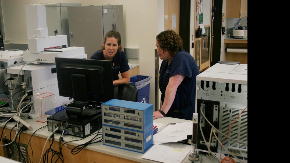 
Melissa Bailey (right) and forensic scientist Julinne Kemp examine a control sample analyzed by a gas chromatograph/mass spectrometer at the Criminalistics Laboratory of the Johnson County Sheriff's Office.
