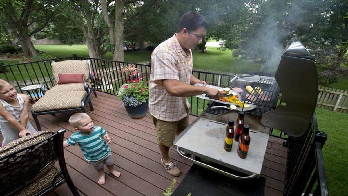
Bill Pikus grilled out on his back deck for family including Paige, 6, and Tyler, 2, on Monday at his home in Overland Park.
