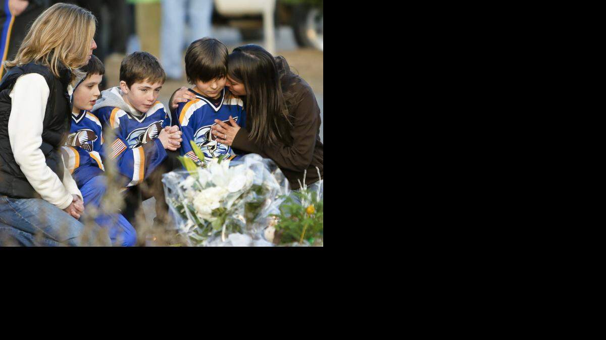 
Shawnee Mission is conducting public forums on it’s security plan this month. The district is trying to prevent a school shooting like the one that happened in Newtown, Conn. From left, Jean Bradley, Steven Turchetta, 9, Jean's son Matthew Bradley, 9, Ashton Baltes, 10, and his mother Elonda Baltes pay their respects at a memorial for shooting victims near Sandy Hook Elementary School in 2012 in Newtown, Conn. 
