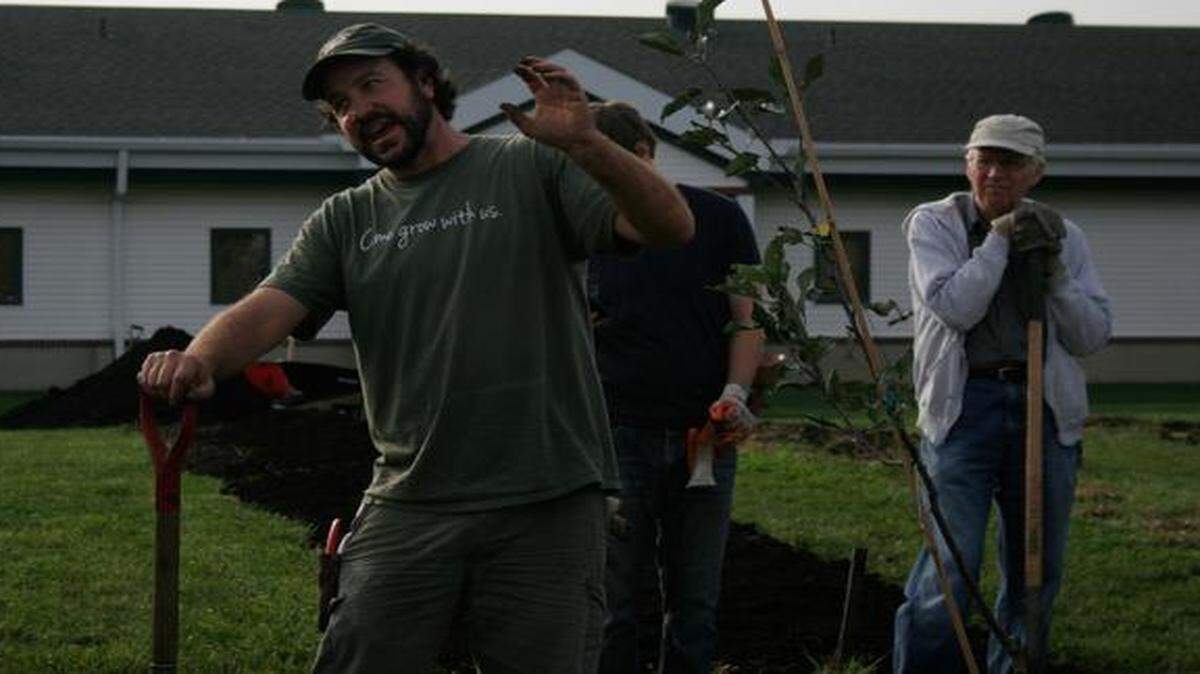  Bunch explains to volunteers how to care for fruit trees.