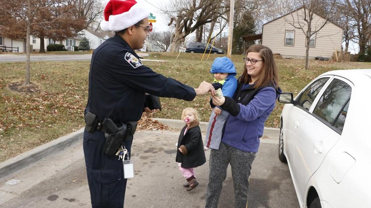 Shawnee Police Community Relations Officer Roman Madrigal surprised Laura Harman, of Overland Park, and her two children with $100 on Wednesday, Dec. 13, 2017, as part of the city’s third annual Secret Santa program. During the last few weeks, more than 80 of the city’s police officers and detectives surprised people in the community with $10,000 in cash gifts from an anonymous donor.