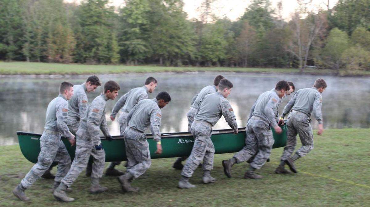 The male team carries the canoe during the physical training test.