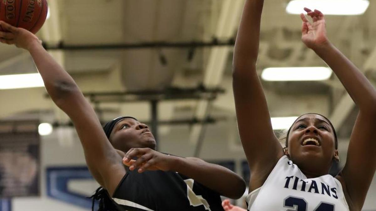 Lee’s Summit sophomore Mikeya House (left) tried to shoot over Lee’s Summit West’s Cayla Vertreese during a Suburban Gold Conference girls basketball game Jan. 23 at West. House scored 19 points but the Titans won 70-39.