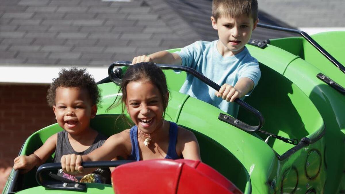 During Friday evening’s Downtown Days carnival, Evelyn and Arianna McCord (left to right, foreground) and Silas Smith shared a happy caterpillar ride.