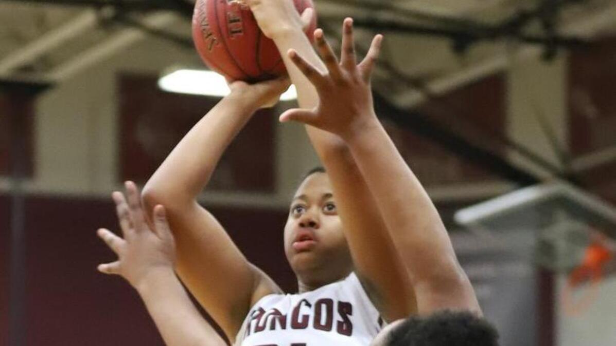 Lee’s Summit North center Aiyana Johnson (left) shot over Lee’s Summit’s Brooke Benton during the Broncos’ 69-42 victory Monday night at North. Johnson finished the game with 17 points.