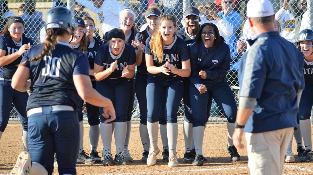 Lee’s Summit West softball players wait for teammate Maddie Harris to touch the plate after hitting a home run during the seventh ininng Wednesday, Oct. 11, 2017, against Lee’s Summit North. Harris’ homer accounted for the only run in the Titans’ 1-0 victory during a Class 4 softball sectional at West.