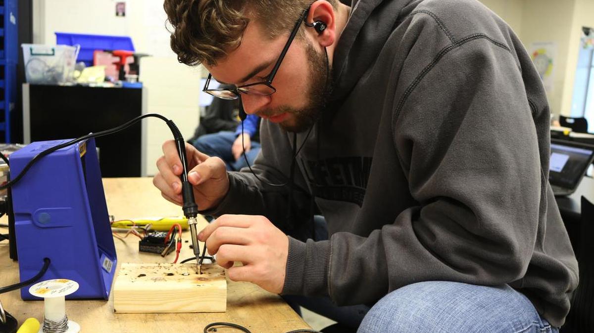 Keigan Andresen, 17, works on his team’s robot at Olathe Northwest High School.