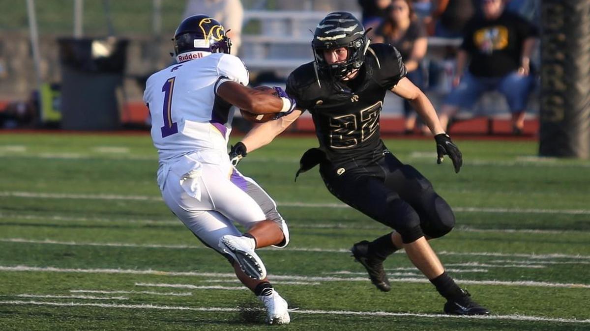Blue Springs running back Michael Warmack tries to avoid Lee’s Summits Evan Sanders Friday night. Warack scored two touchdowns for the Wildcats in their 43-7 season-opening win.