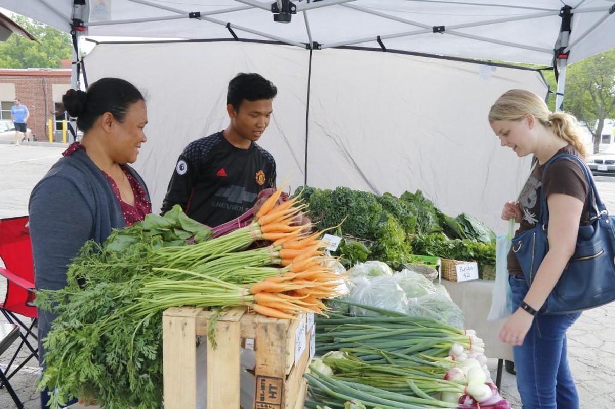 Grower and vendor Lee Meh and her son, Htay Reh, 17, chatted with customer Emily de Melo about their farm-fresh produce during a recent downtown Lee’s Summit Farmers Market.