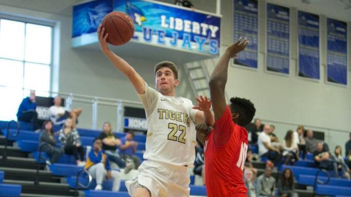 Lee’s Summit’s Seth Romi (left) glided past Shawnee Mission North’s Jackson Bell for a layup Saturday, Dec. 2, 2017, during the 810 Varsity Tipoff Classic at Liberty. Romi’s Tigers dominated the season-opening matchup 82-54.