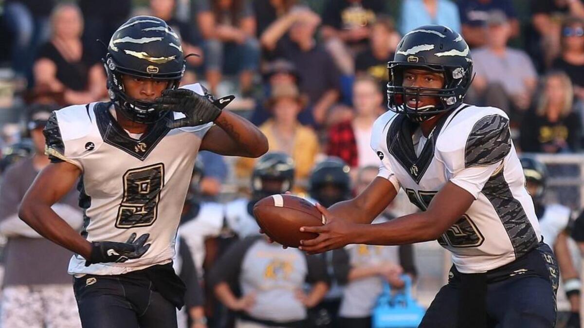 Lee’s Summmit quarterback Darrias Pearsall (right) hands the ball off to wide receiver Somaj Brewer Friday night against Fort Osage. Lee’s Summit scored the first 14 points before falling to the Indians 35-14 at Fort Osage.