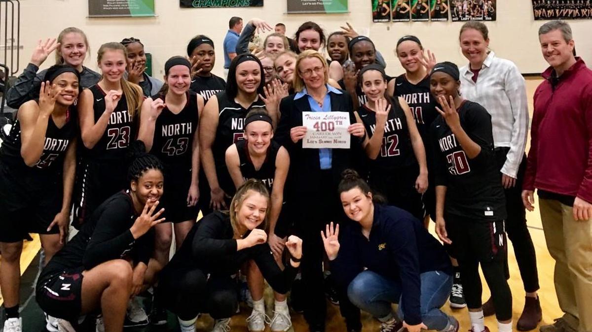 Lee’s Summit North girls basketball coach Tricia Lillygren (center) was surrounded her players and assisant coaches after recording her 400th career victory Monday at Staley.