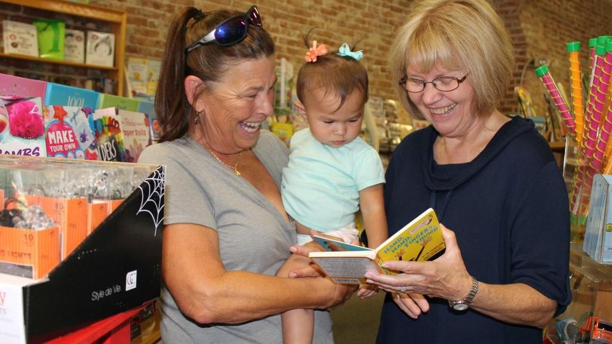 Cheryl Collier (right) discusses books with Cindy Frantsen and her grandbaby, Mariah Hart, 15 months.
