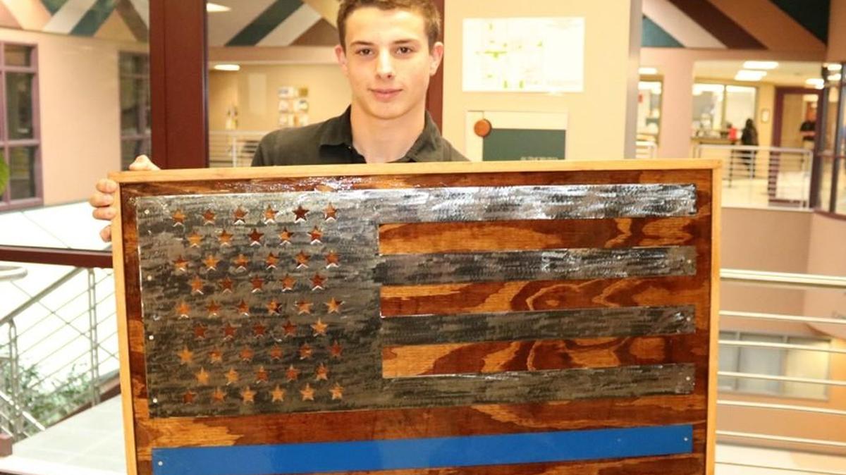 Cameron Fisher with the flag project he made in a Lee’s Summit High School metals class, which is now on display at the Lee’s Summit Police Department.