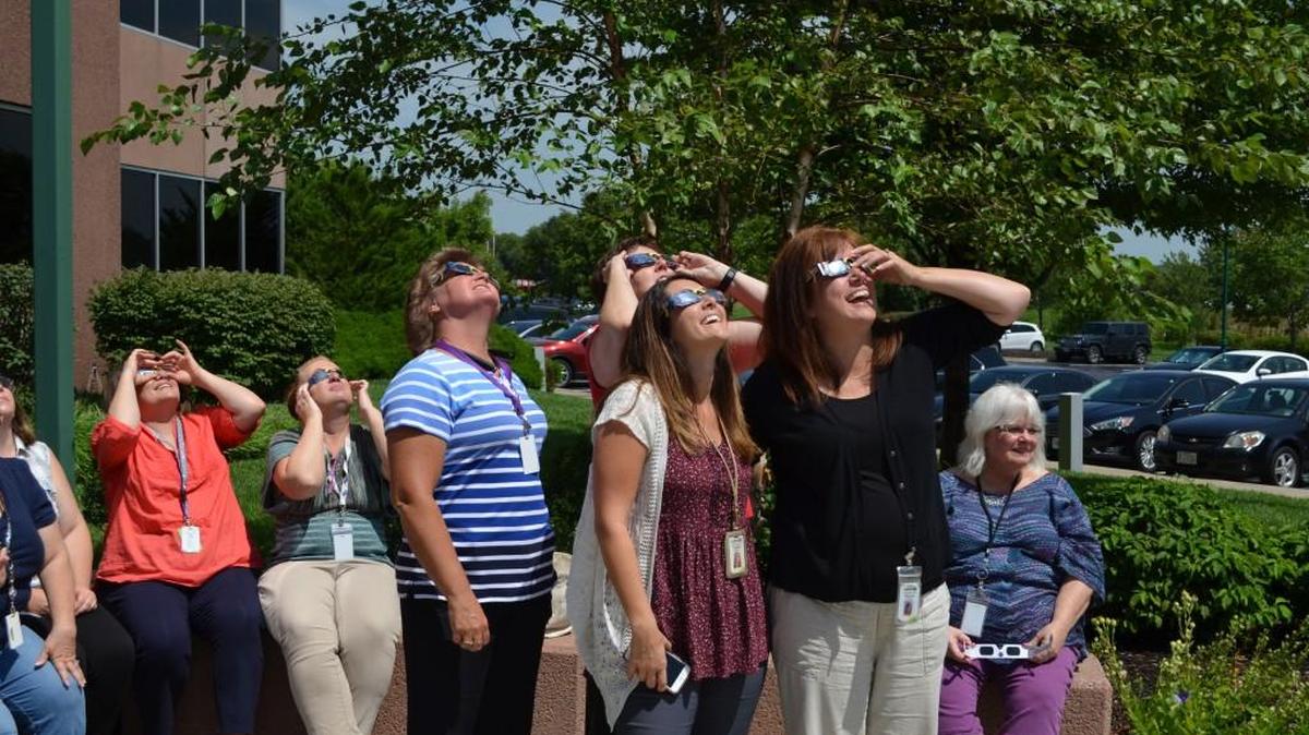 Employees take a break from work to view the 2017 eclipse from the GEHA Landmark building, 2201 E. Jackson Drive in Independence.