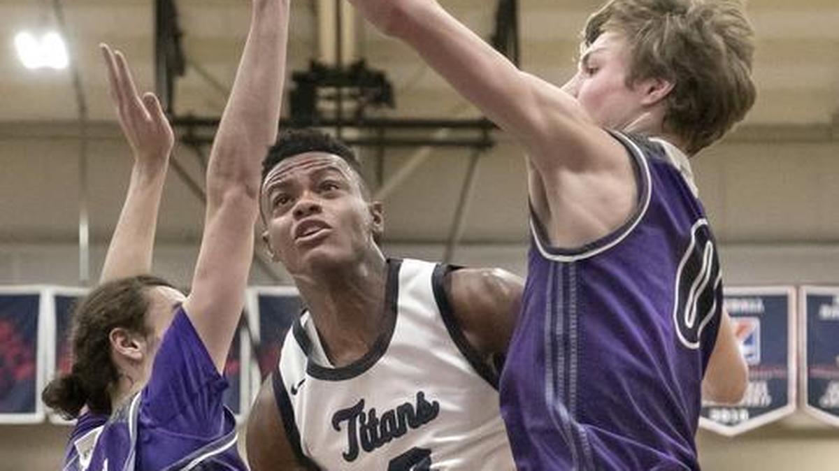 Lee’s Summit West’s Mario Goodrich (center) squeezed between Blue Valley Northwest defenders Parker Braun (left) and Christian Braun (right) on Saturday, Dec. 16, 2017, during the Cable Dahmer Shootout at Avila University in Kansas City, Mo. Goodrich finished with 11 points, including several key free throws down the stretch, during the Titans’ 57-52 victory.