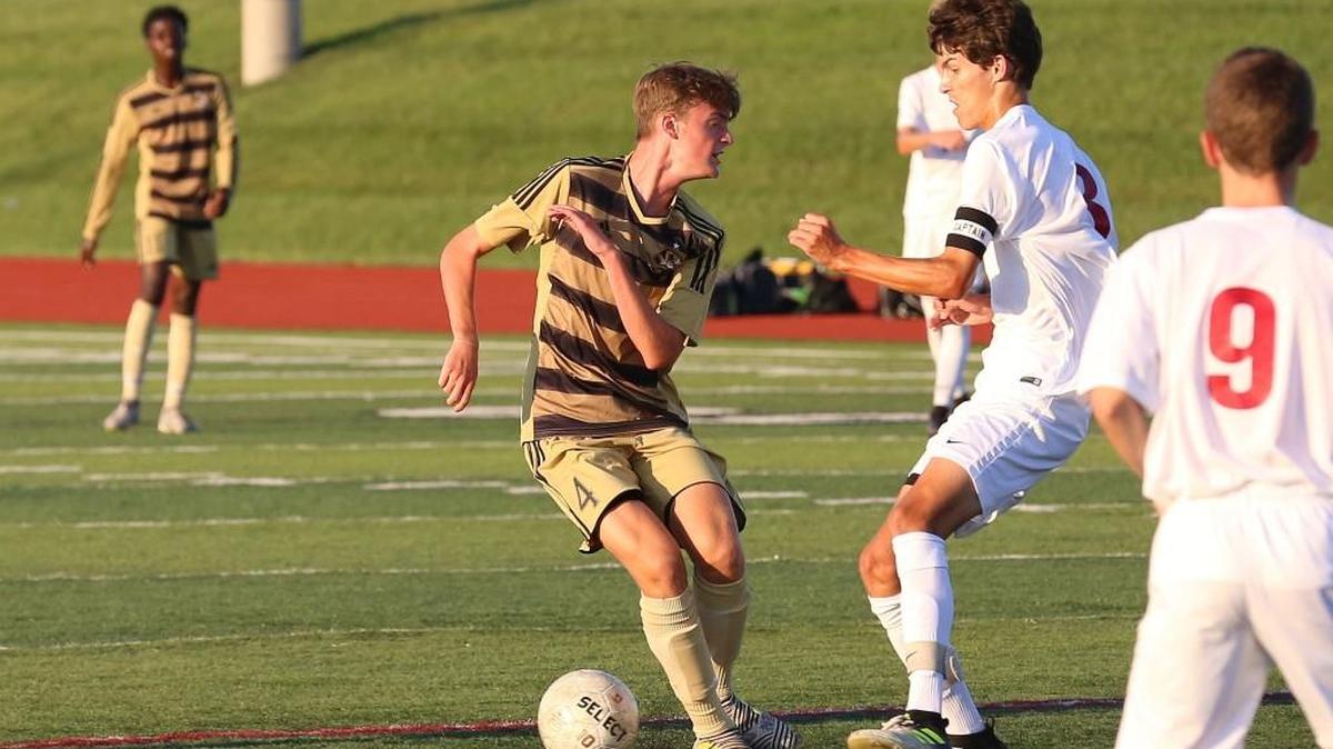 Ian Shores of Lee’s Summit tries to get by Kyle Rock of Lee’s Summit North Wednesday night. Lee’s Summit won the Suburban Gold Conference match at North 4-1.