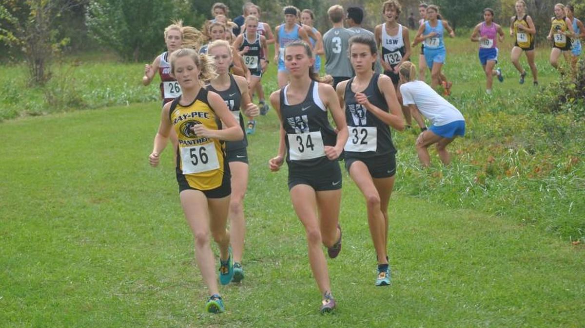 Addie Mathis (center) and Madison Hulsey (right) of Lee’s Summit West try to keep pace with Raymore-Peculiar’s Makenzie Stucker during the girls race in the Class 4 District 6 cross country meet Saturday at Raymore-Peculiar. Hulsey took fourth and Mathis was fifth for the Titans, who finished second behind Ray-Pec.
