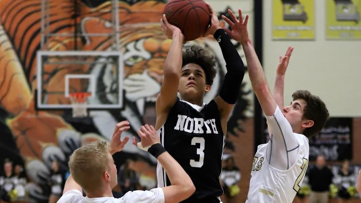 Lee’s Summit North’s Javaunte Hawkins (center) shot between Lee’s Summit defenders Tevor Langenbahn (left) and Seth Romi (right) on Friday, Jan. 19, 2018, during the fifth-place game of the Culver’s Classic at Lee’s Summit. Hawkins made five three-pointers and finished with 21 points during North’s 75-74 victory.