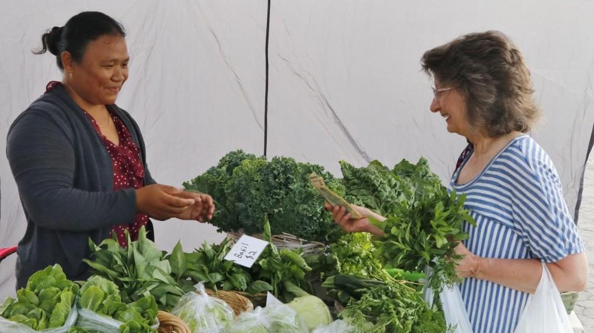 At a recent Saturday morning Lee’s Summit Farmers Market, Gloria Summers of Oak Grove purchased fresh basil from grower and vendor Lee Meh.