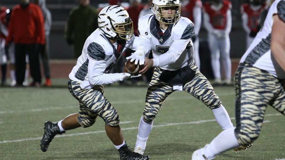 Lee’s Summit running back Davion Gravitt (left) takes a handoff from quarterback Preston Whitworth during the Class 6 District 4 semifinal against Park Hill Friday. The Tigers’ season ended with a 21-10 loss at Park Hill.