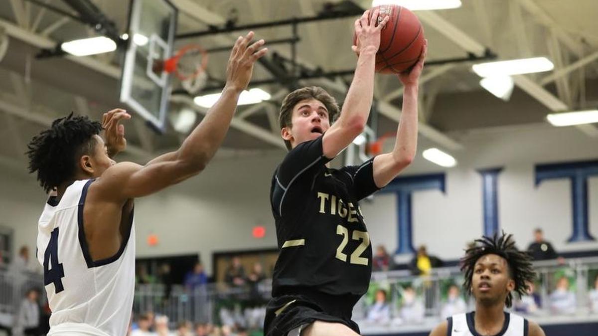 Lee’s Summit senior guard Seth Romi (center) went up for a shot Jan. 23 between Lee’s Summit West’s Phillip Brooks (left) and Rich Johnson. Romi’s three-pointer with 14 seconds left lifted the Tigers to a 49-48 Suburban Gold Conference victory at West.
