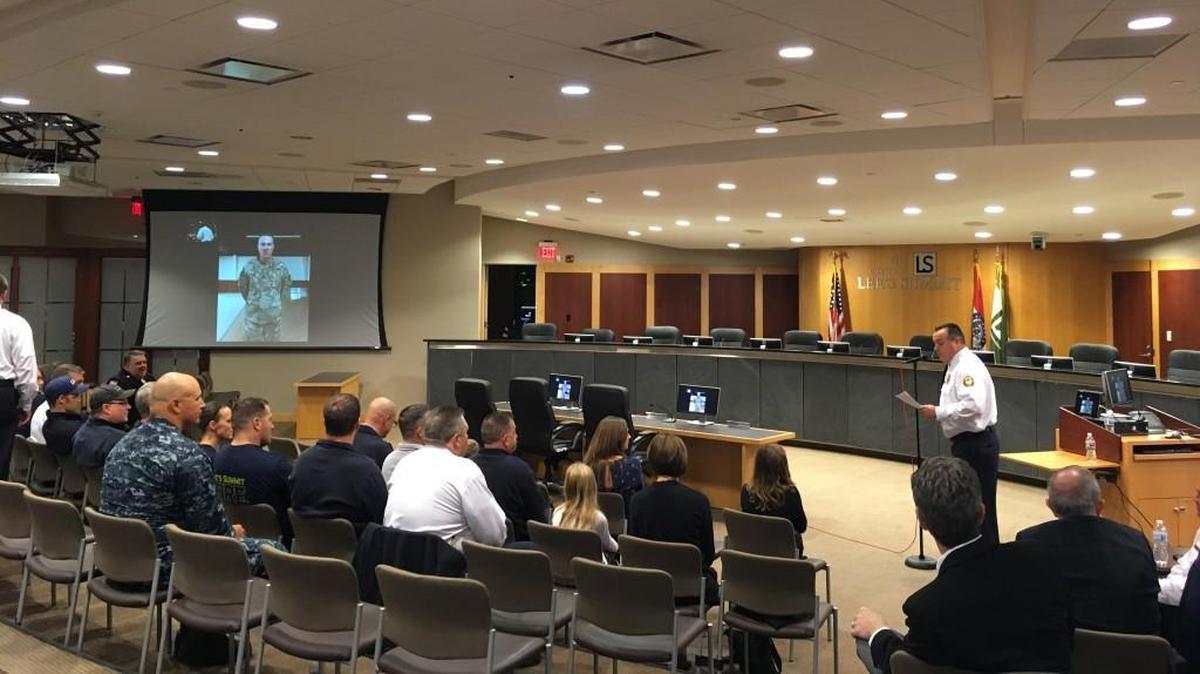 Lee’s Summit Fire Department Chief Rick Poeschl (right, standing) promoted Paramedic/Specialist Ben Hicks (left, on video screen) to the rank of captain Saturday, Nov. 4, 2017, via FaceTime during a ceremony at Lee’s Summit City Hall. Missouri National Guard 1st Lt. Hicks is currently deployed with the 138th Infantry Division in Qatar.