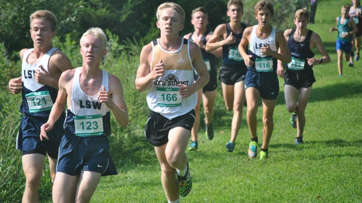 Layne Breneman (right) of Lee’s Summit runs with Will Cantrell (left) and Mason Gray (center) of Lee’s Summit West in the varsity boys race in the Solsberg Invitational Saturday at Lake Jacomo. Breneman finisehd 18th for the Tigers, while Carroll was 12th and Gray 21st for the Titans.
