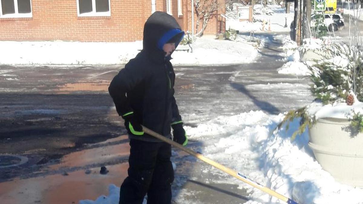 Jackson Wichman, age 9, helped shovel snow in Downtown Lee's Summit.