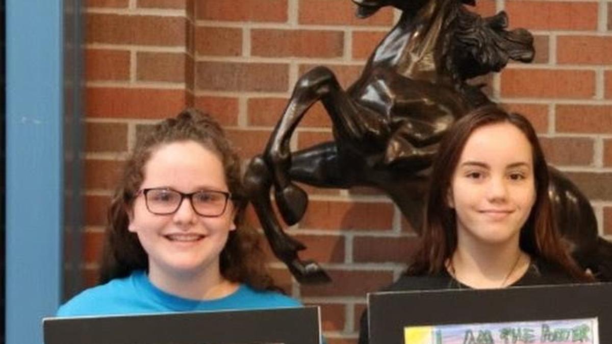 Kenna Schmidt (left) and Clarity Qualls (center) display their award-winning artwork with art teacher Jewelee Lukowski.