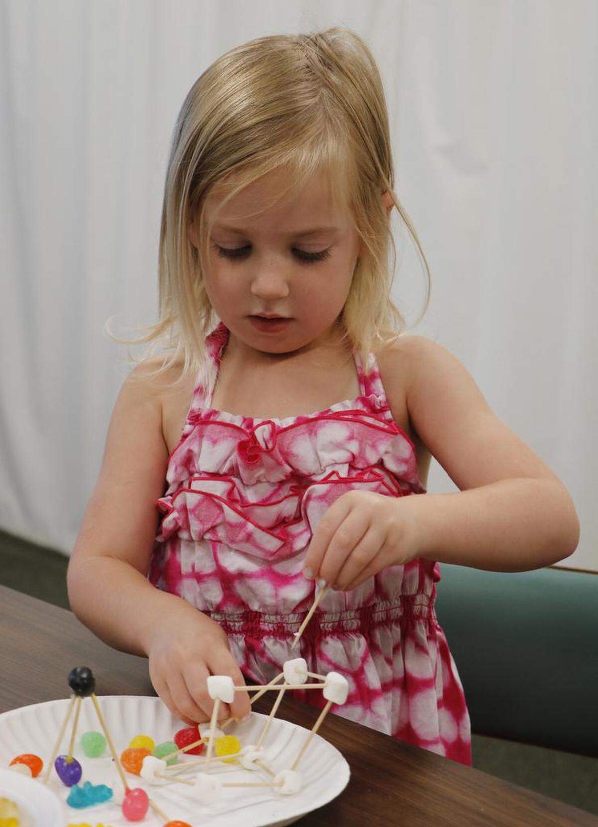 Jenna Toliver, 3, was fully focused on building a tall, sturdy tower from marshmallows and toothpicks during Monday’s STEAM program at the Lee’s Summit Library.