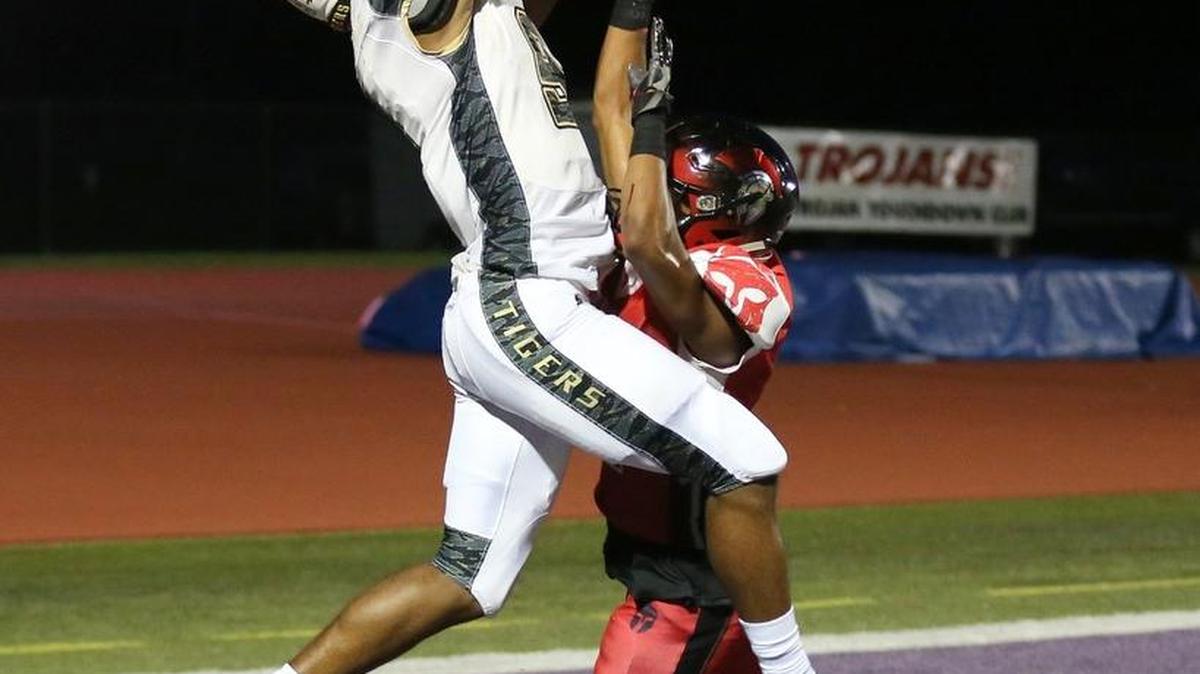 Lee’s Summit wide receiver Somaj Brewer leaps over a Park Hill defender for a ball in the end zone Friday night. Brewer made five catches for 127 yards and three touchdowns in the Tigers’ 66-35 loss.