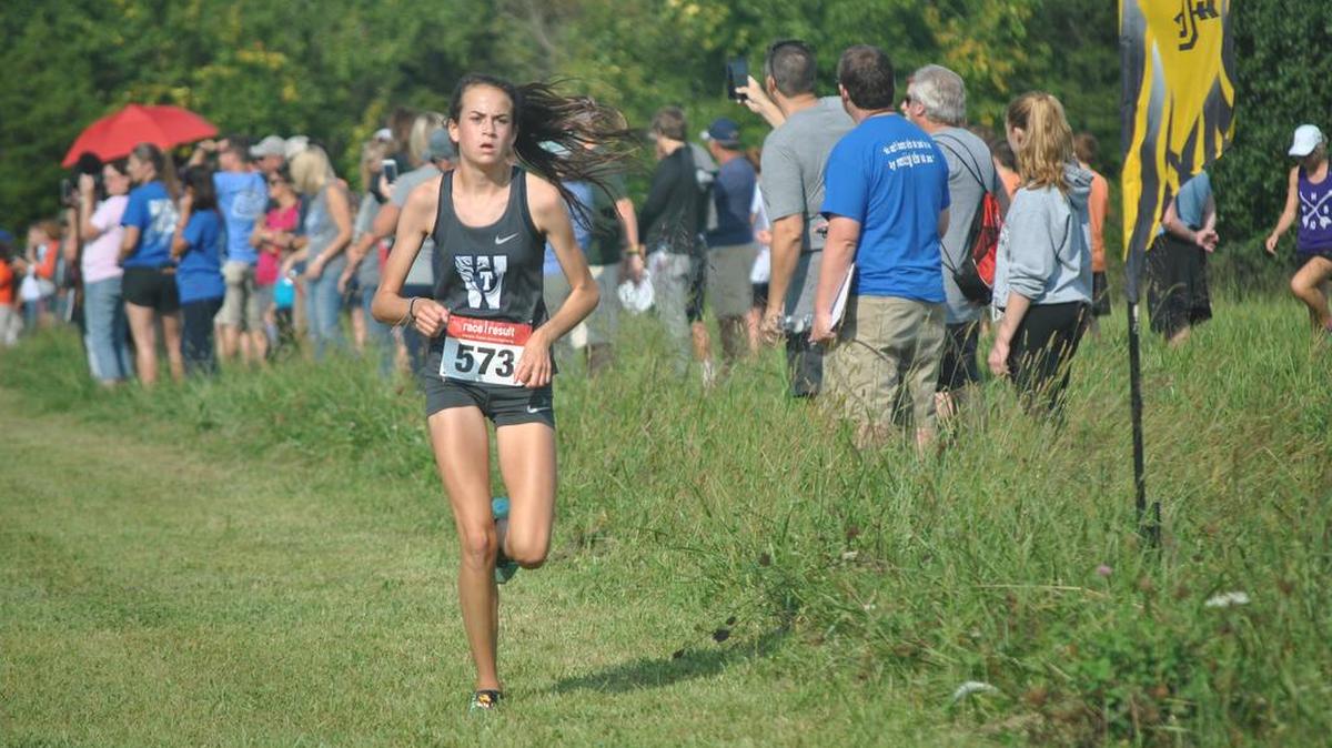 Maddie Hulsey of Lee’s Summit West make her way down the course during the girls varsity race in the Raymore-Peculiar Invitational cross country meet Saturday. Hulsey’s fifth-place finish led the Titans, who won the Large Schools Division team championship.
