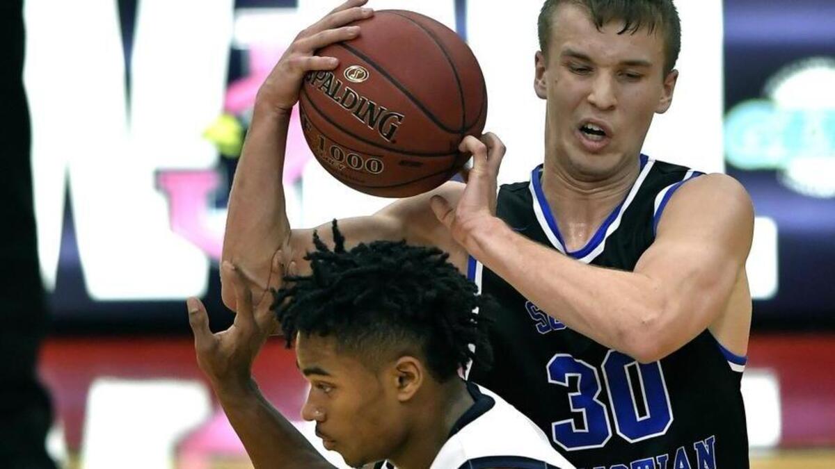 Summit Christian Academy’s Preston Kliewer kept the ball away from Lee’s Summit West guard Phillip Brooks on Dec. 28 at the William Jewell Holiday Classic in Liberty. The Eagles fell to the Titans 60-44 and later to Staley 66-52 during its first appearance in the annual holiday tournament.