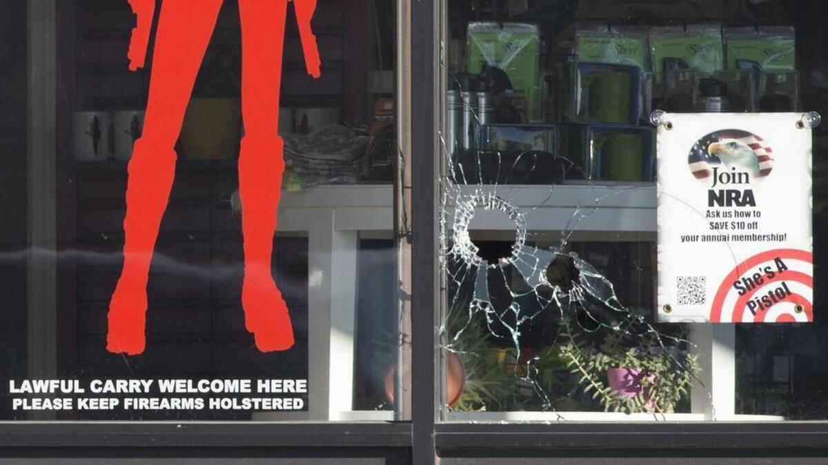 Bullet holes could be seen in the window of She's A Pistol, a firearms store at 5725 Nieman Rd., in Shawnee.