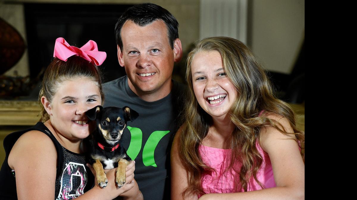 
Kansas City Police Officer Jeff O'Rear and his partner rescued a 6-month-old Chihuahua mix that was locked in a hot car Saturday for nearly two hours. On Wednesday, O'Rear surprised his daughters, 8-year-old Melaina O'Rear (left) and Michelle O'Rear, 13, by adopting the dog he helped save. The Chihuahua does not have a new name yet.

