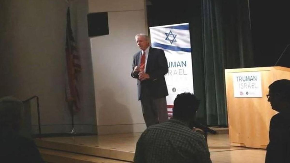 Jeremy Rothe-Kushel, of Lawrence (foreground), asked a question of guest speaker Dennis Ross at the Kansas City Public Library before he was seized by security and arrested by off-duty Kansas City police officers.