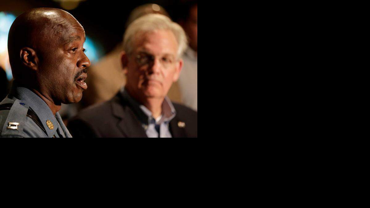 
Missouri Gov. Jay Nixon listend as Missouri Highway Patrol Capt. Ron Johnson (left) answered questions at a Saturday news conference dealing with the aftermath of a police shooting of teenager Michael Brown in Ferguson, Mo. Nixon declared a state of emergency Saturday and imposed a curfew in a St. Louis suburb, where police and protesters have clashed after a black teenager was shot to death by a white police officer a week ago.
