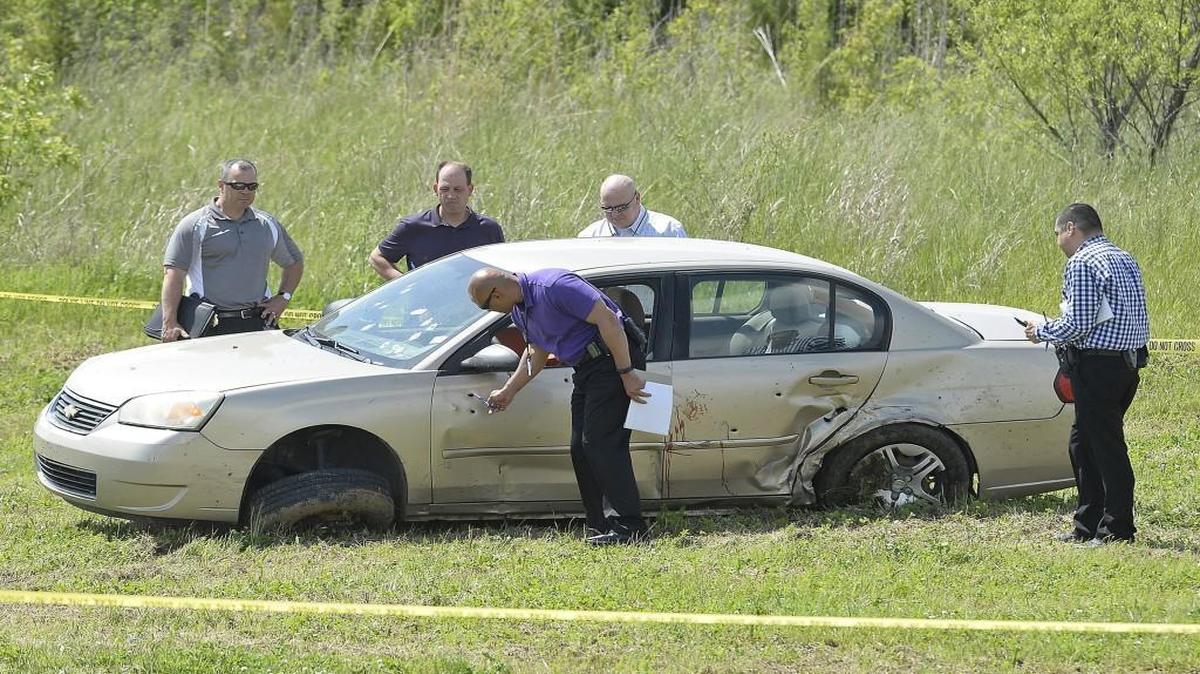 Authorities investigated one of two cars at 118th Street and State Avenue in Kansas City, Kan., after a police detective was shot near Kansas Speedway on Monday. The car, which was thought to be connected to the shooting, was riddled with bullet holes, which can be seen in the driver’s side of the car.
