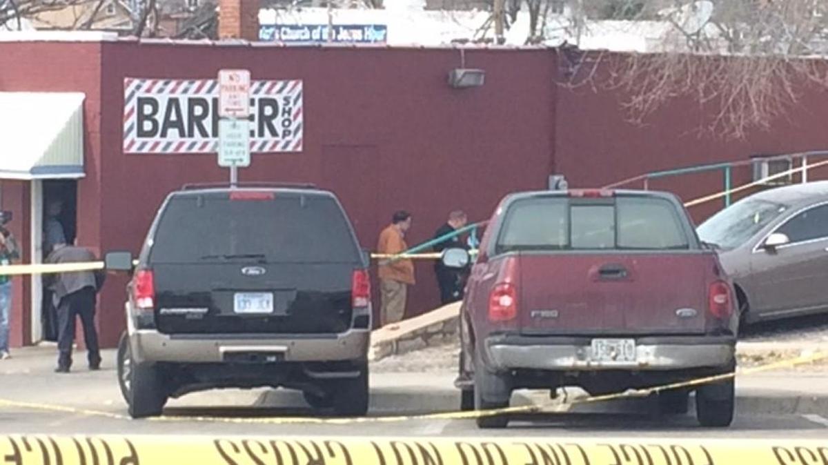 Detectives examine the homicide scene Friday outside a barber shop on Minnesota Avenue in Kansas City, Kan.