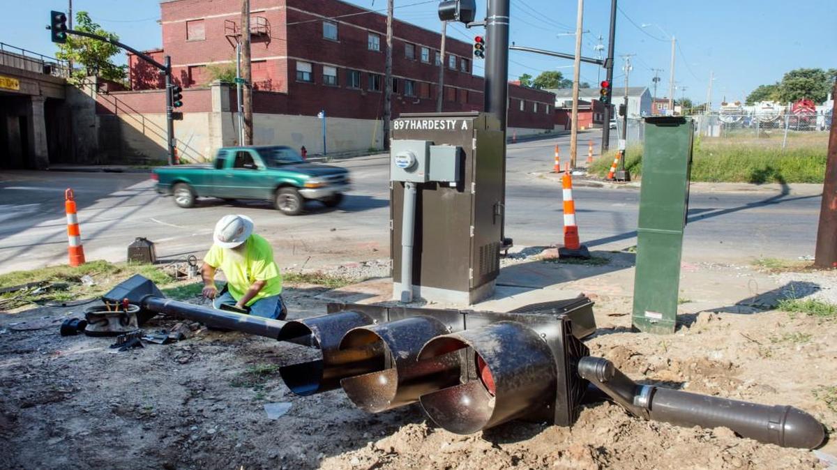 
Dave Wamsley, an electrician with Mark One Electric, repaired a traffic signal on Wednesday at Hardesty Avenue and Ninth Street. The light was damaged late Tuesday in a shooting and wreck that killed one person and injured several others, including six children.
